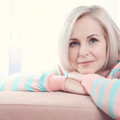Woman smiling with arms resting on table